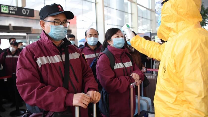 Bei Mitgliedern eines chinesischem Ärzteteams wird die Körpertemperatur gemessen, bevor sie Zhongchuan International Airport in Lanzhou betreten dürfen.