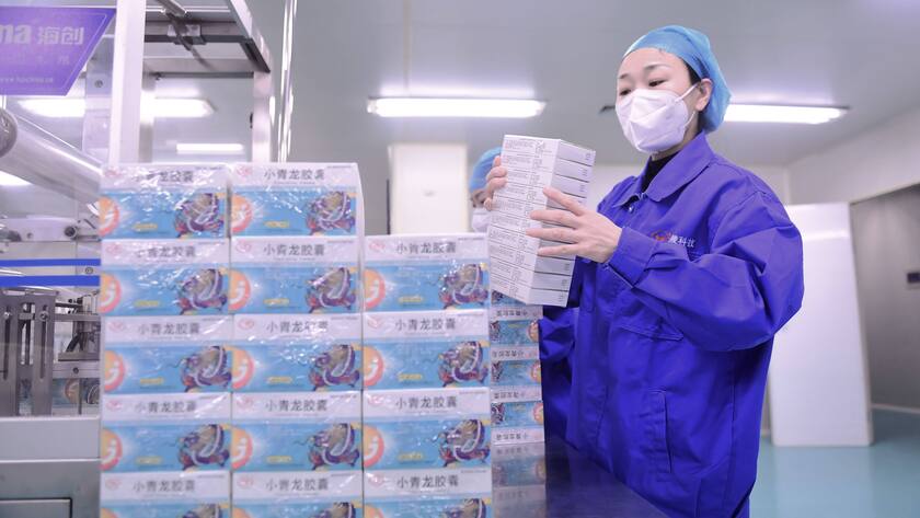 Eine Arbeiterin stapelt Packungen von Produkten bei Shenyang Dongling Pharmaceutical in Shenyang, China.