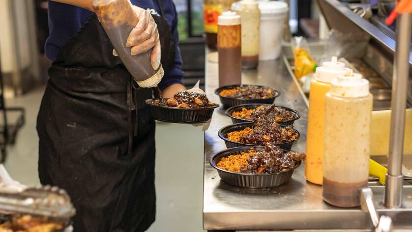 Ein Mitarbeitender bereitet in Detroit, USA im Restaurant Yum Village Essen zu.