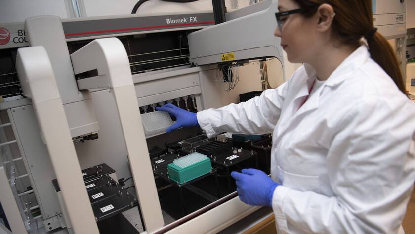 Labormitarbeiterin an einem Roboter in Uppsala, Schweden, bei Coronavirus-Test.