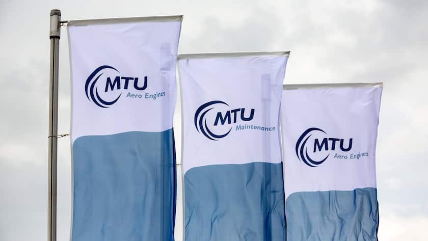 Das Logo von MTU auf Fahnen an einer Messe in Berlin.