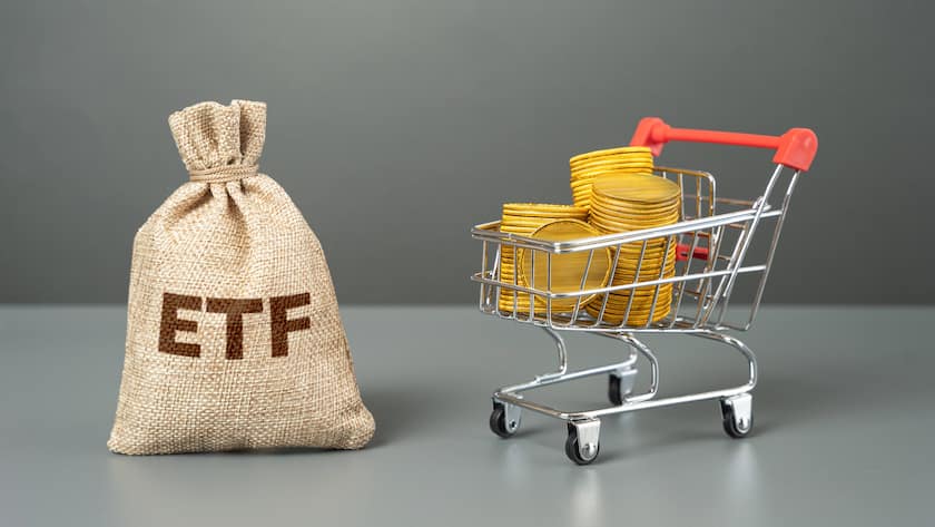 Börsengehandelter Fonds und Einkaufswagen mit Geldmünzen.