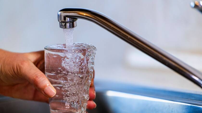 Trinkwasser läuft aus dem Wasserhahn in ein Glas.
