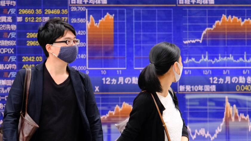 Passantinnen in Tokio vor Kurstafeln mit aktuellen Börsen-Kursen.