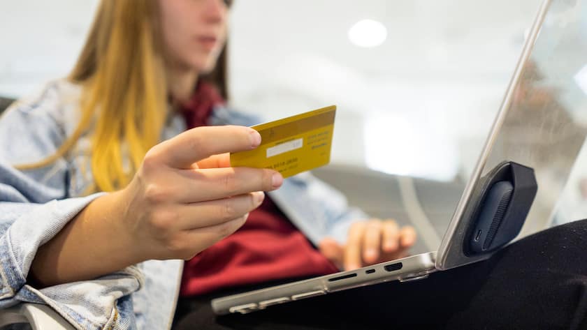 Eine junge Frau zahlt online mit Karte.