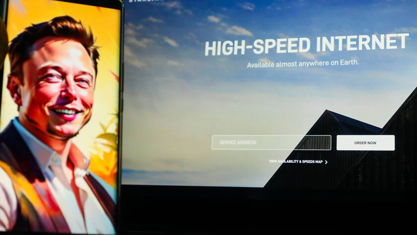 Elon Musk abgebildet mit der Starlink-Website im Hintergrund.