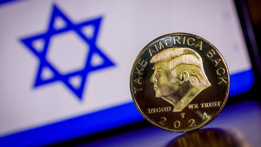 Eine Münze (Trump Coin) mit dem Gesicht von Donald Trump ist symbolisch vor einer israelischen Flagge zu sehen (Februar 2025).