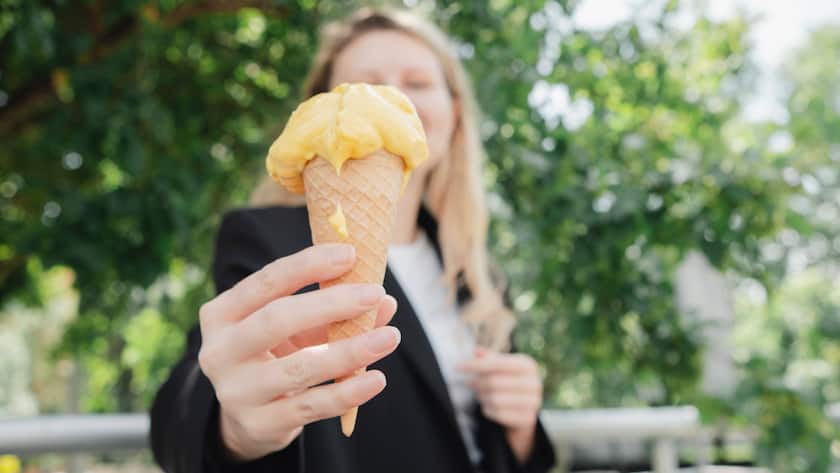 Eine Frau hält ein Glace hoch.