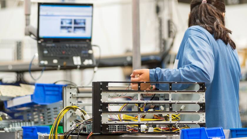 Eines Technikerin repariert einen Computerteil.