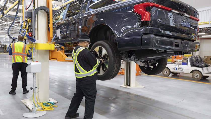 Zwei Arbeiter bei der Endmontage eines elektrischen Ford Pickup F-150 Lightning in Dearborn, USA (2023).