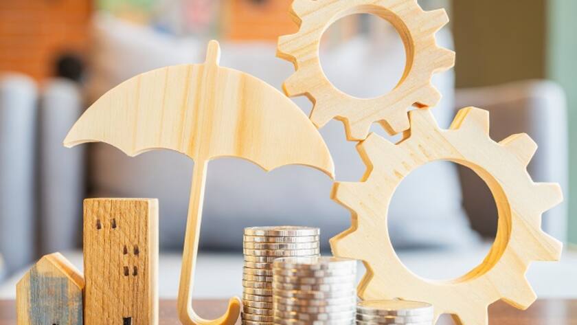 Modell des Regenschirms mit Haus und Münzen - Konzept des Systems der Versicherung.