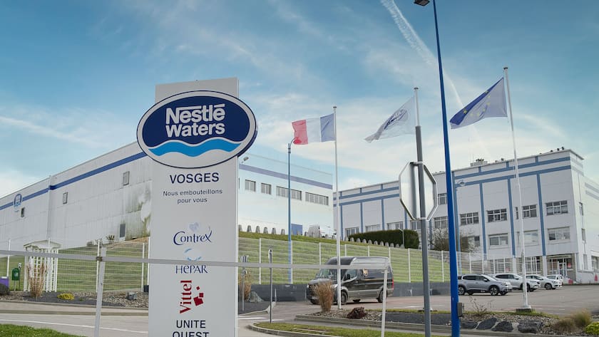 Eine Kulisse der Mineralwasserfabrik Vittel mit einem Schild von Nestle Waters im Vordergrund (2022).