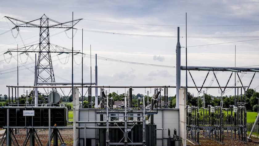 Hochspannungsmasten stehen in der Landschaft.