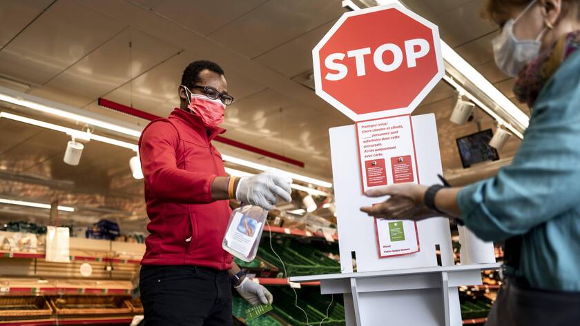 Mundschutz und Handdesinfektion in einem Supermarkt in Lausanne.