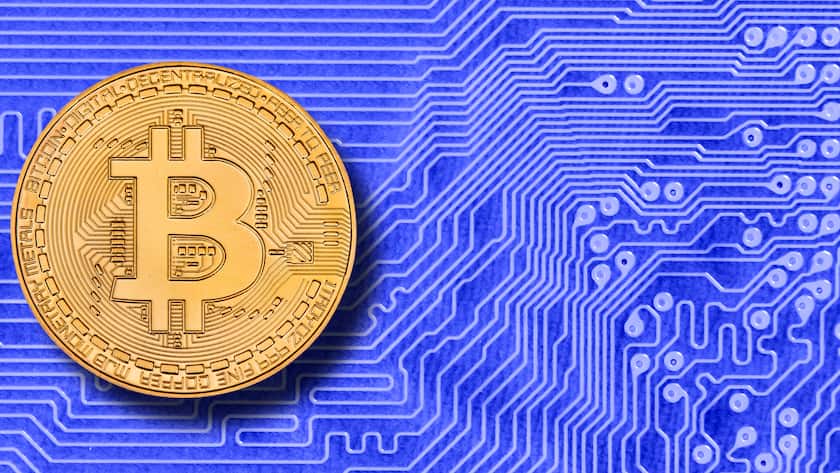 Eine Münze der Kryptowährung Bitcoin liegt auf einem digitalen Netzwerk.
