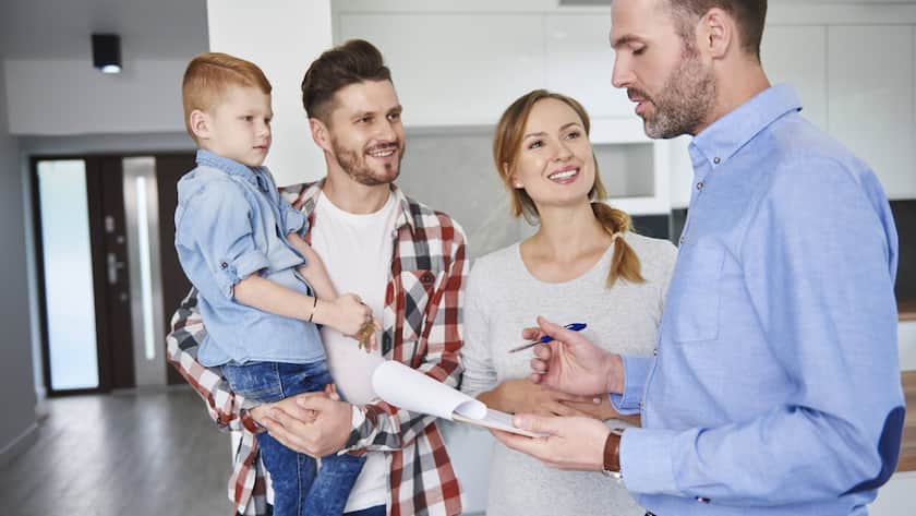 Ein Paar mit Kind besichtigt eine neue Wohnung.