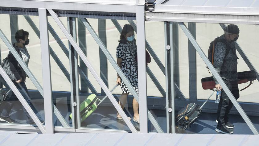 Masken und Abstand: Passagiere verlassen am Flughafen Zürich ein Flugzeug über ein Fingerdock.
