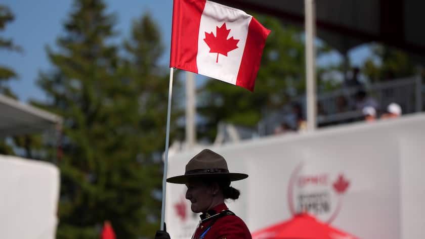 Kanadische Polizistin hält die Nationalflagge an einem Golfturnier in Edmonton.