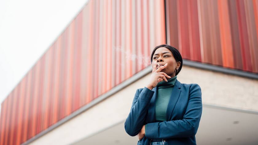 Eine Frau raucht in ihrer Pause.