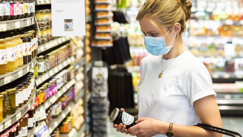 Supermarkt in London: Frau trägt beim Einkauf vom Lebensmitteln eine Maske.