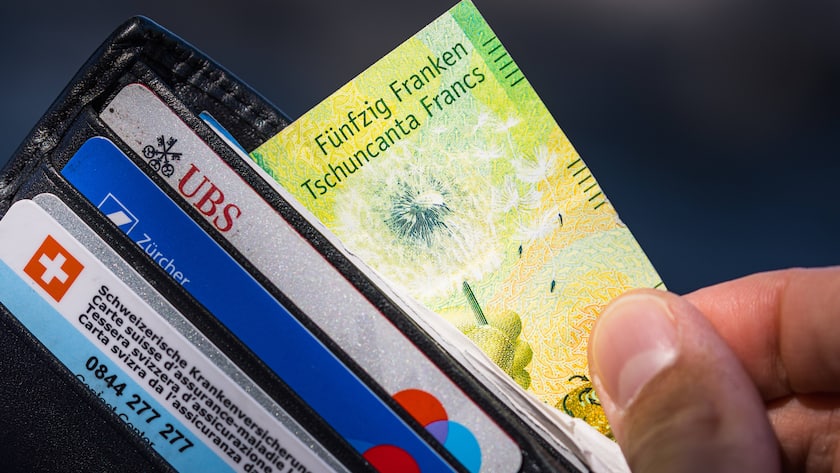 Die starken Portemonnaies: In welchen Regionen die Schweizer am kaufkräftigsten sind Ein junger Mann zieht eine Banknote mit dem Wert von fünfzig Schweizer Franken aus dem Portemonnaie (2022).