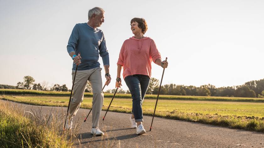 Ein älteres Paar hat Freude am Nordic Walking.
