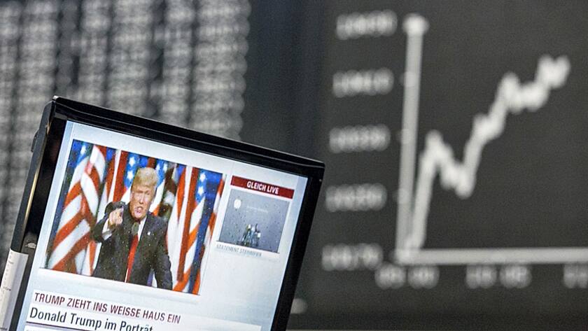 A television news report shows U.S. President-elect Donald Trump as the DAX Index curve shows market reaction inside the Frankfurt Stock Exchange in Frankfurt, Germany, on Wednesday, Nov. 09, 2016.