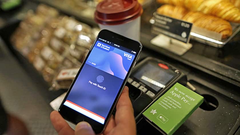 A customer uses an Apple Inc. iPhone to pay via the Apple Pay system, from their Royal Bank of Scotland account, at the check-out till inside a Pret A Manger Ltd store in this arranged photograph in London, U.K., on Tuesday, July 14, 2015.