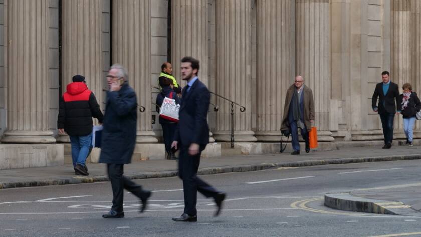 Fussgänger vor der säulenverzierten Fassade der Bank of England in der Londoner City.