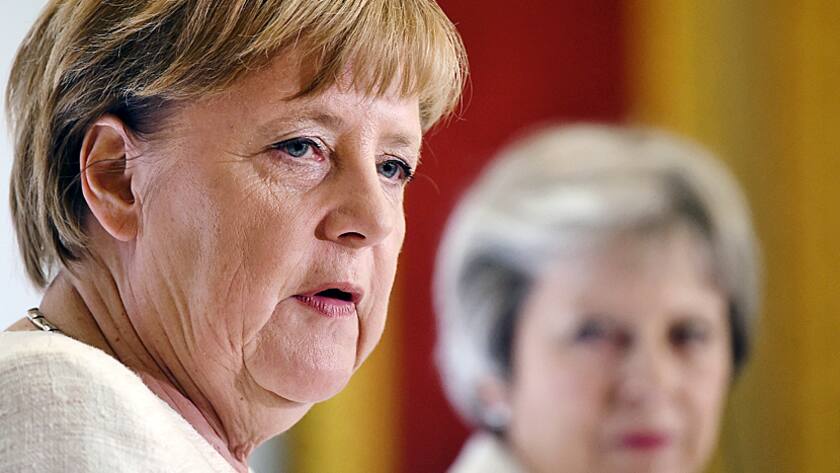 Die britsiche Premierministerin Theresa May (hinten) lauscht an einer Pressekonferenz in London den Worten der deutschen Kanzlerin Angela Merkel (10.7.2018).