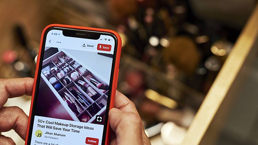 Ein Mann nutzt Pintrest auf seinem Handy.