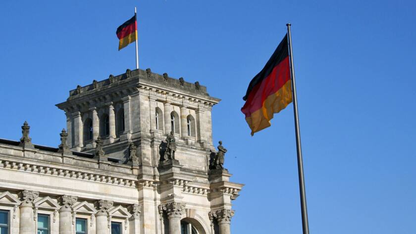 Deutsche Flaggen vor und über dem Reichstagsgebäude in Berlin.