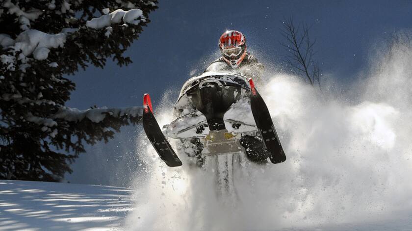 Ein Schneemobil setzt zum Sprung an.