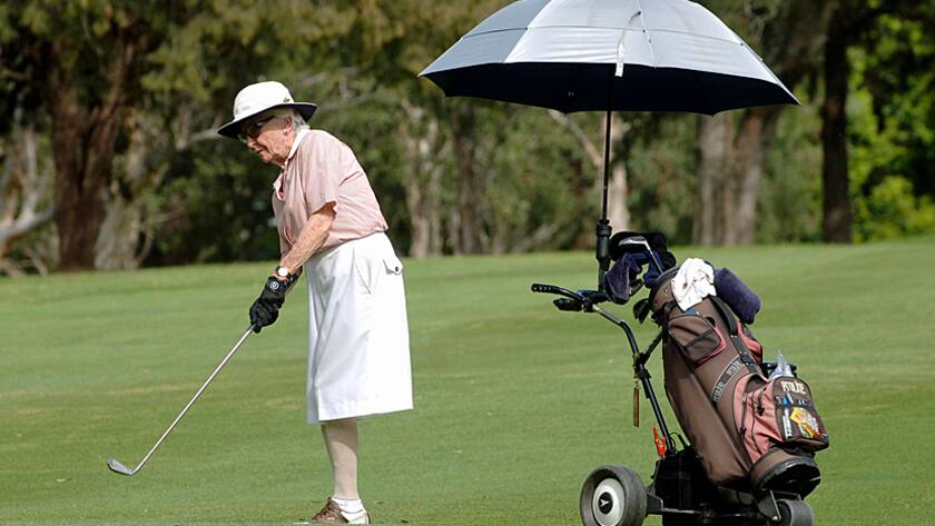 Eine Seniorin vergnügt sich beim Golfen.