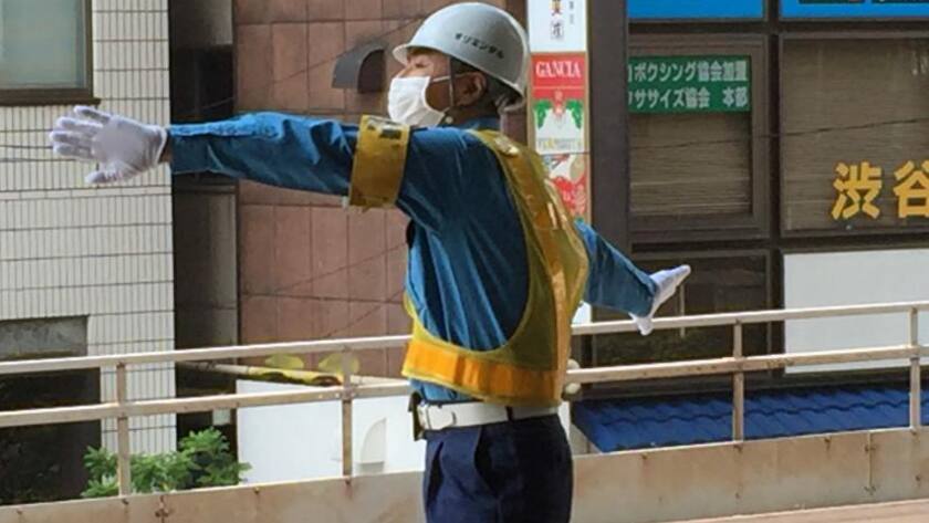 Bahnangestellter in Tokio sorgt am Perron für Ordnung.