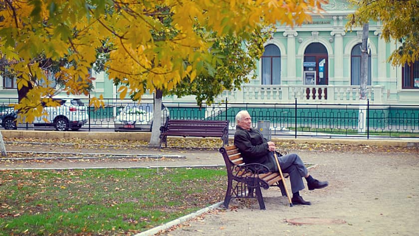 Ein Rentner geniesst die Ruhe in einem Park.