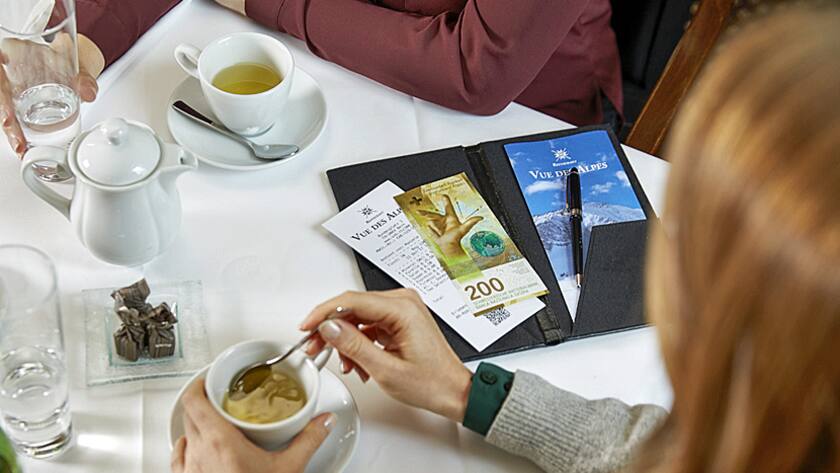 Gäste in einem Restaurant bezahlen ihre Rechnung bar mit einer neuen 200-Franken-Note.