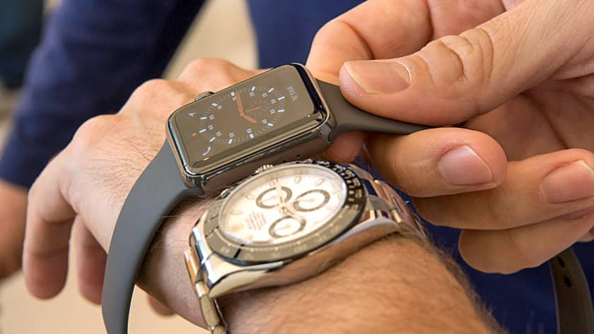 Ein Kunde vergleicht eine Apple Watch Serie 3 mit seiner konventionellen Armbanduhr.