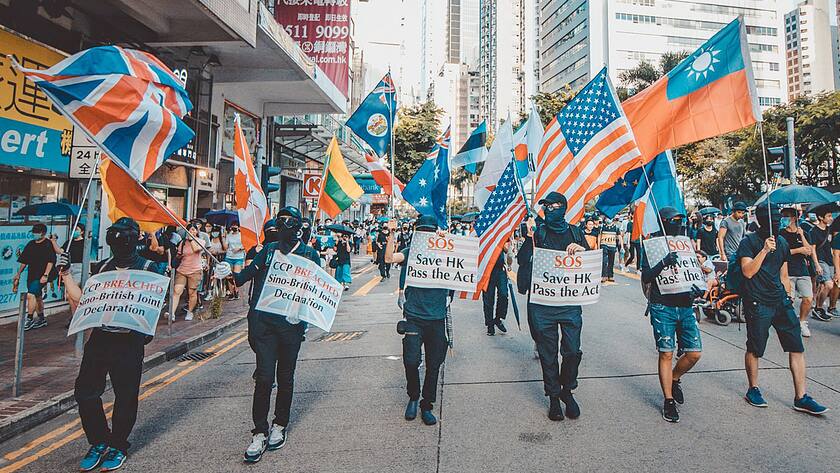 Demonstranten in Hongkong tragen Flaggen verschiedener Länder, unter anderem der USA.