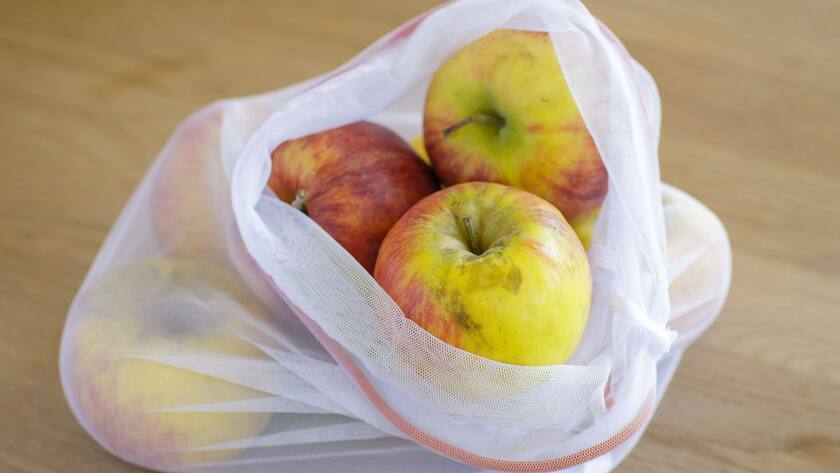 Symbolfoto unverpackte Lebensmittel. Äpfel sind in einem wiederverwendbarem Einkaufsnetz verpackt.