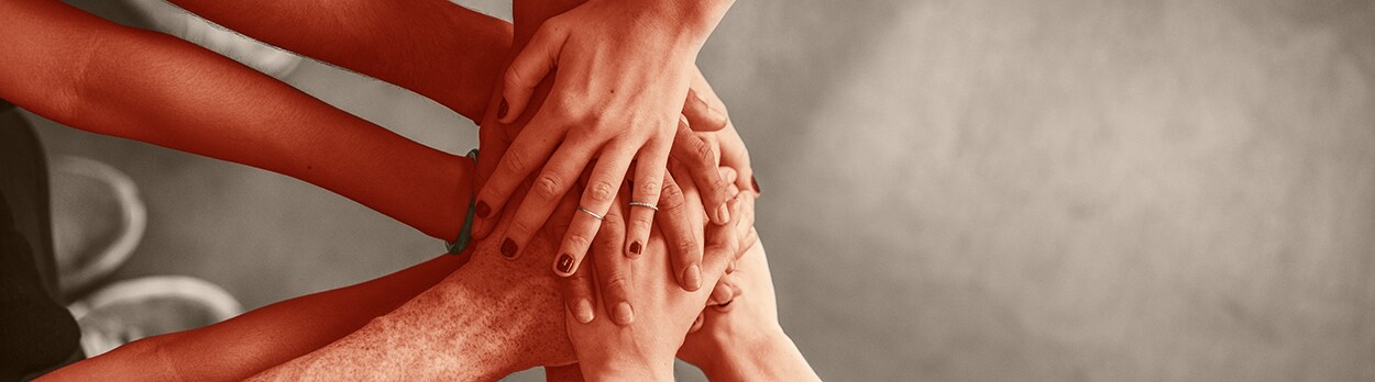 Close up top view of young people putting their hands together. Friends with stack of hands showing unity and teamwork.